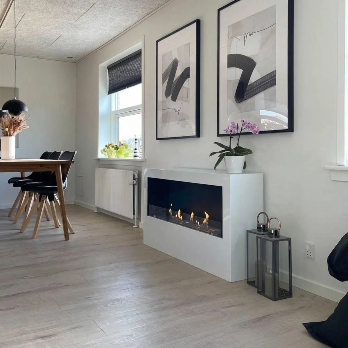 ScandiFlames Bismarck white bioethanol fireplace lit with several flames in a kitchen-dining living space